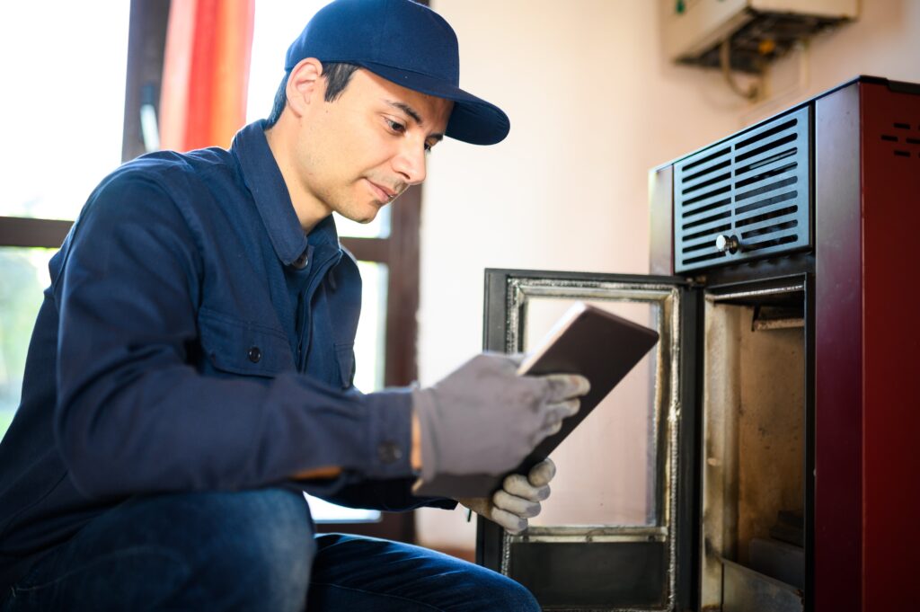 technician-maintaining-pellet-stow-heater-min